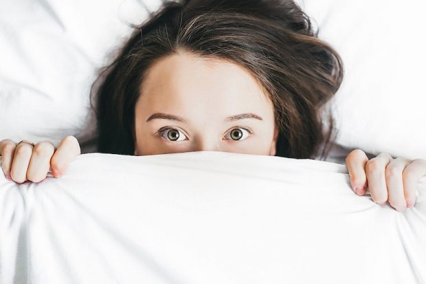Femme se cache sous la couette