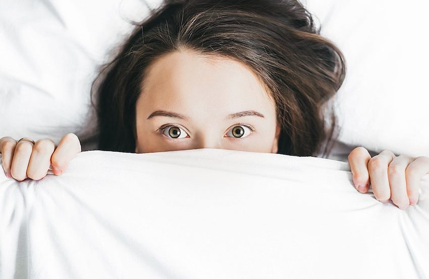 Femme se cache sous la couette